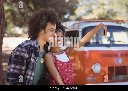 Glückliche Frau mit Freund, die Selfie auf dem Feld macht Stockfoto