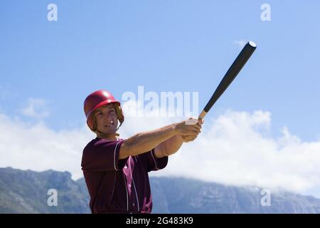 Baseballspiele schlagen mit Schläger gegen Berg Stockfoto