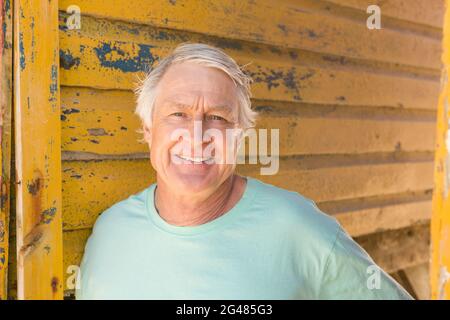 Porträt eines lächelnden Mannes, der gegen die Strandhütte steht Stockfoto