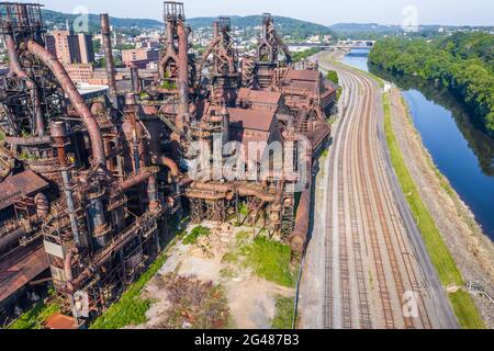 Luftaufnahme einer verlassenen Stahlfabrik entlang einer Eisenbahn und Wasser, in Pennsylvania. Stockfoto