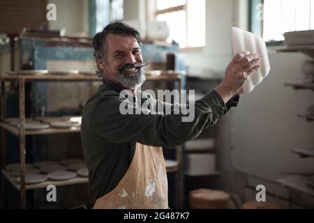 Porträt von männlichen Töpfer Überprüfung keramische Schüssel Stockfoto