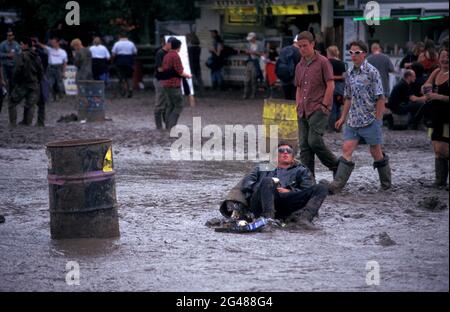 Mann, der 1998 auf einem Mülltonnen im Schlamm schlief, Glastonbury Festival, Pilton, Somerset, England Stockfoto