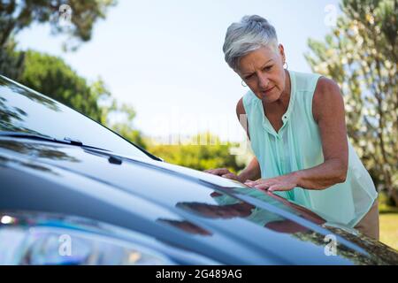 Ältere Frau überprüft ihr Auto Stockfoto