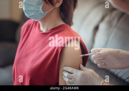 Eine Frau wird geimpft, Coronavirus, Covid-19 und Impfkonzept. Stockfoto