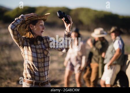 Schockierte Frau mit Fernglas während des Safarieraulaubs Stockfoto