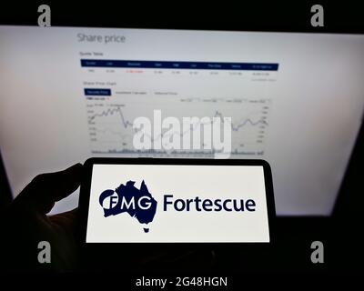 Person, die ein Smartphone mit dem Logo des australischen Bergbauunternehmens Fortescue Metals Group Ltd auf dem Bildschirm vor der Website hält. Konzentrieren Sie sich auf die Telefonanzeige. Stockfoto