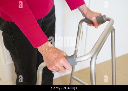 Alte Person mit Gehrahmen im Haus Stockfoto