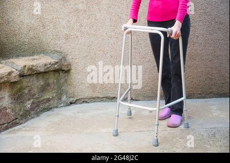 Alte Person mit Gehrahmen im Haus Stockfoto