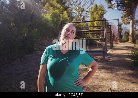 Müde Frau, die mit der Hand auf der Hüfte im Stiefellager steht Stockfoto