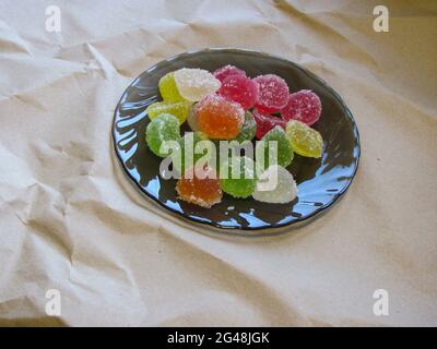Ein Bündel von bunten Marmelade bestreut mit Zucker auf einem Schwarze Platte Stockfoto