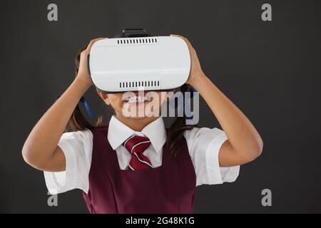 Schulmädchen mit virtual-Reality-Kopfhörer gegen Tafel Stockfoto