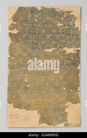 Fragment gelber Samiet mit blauem und weißem Muster von kreisförmigen Medaillons und Papageien. Ziemlich geformtes Fragment gelbes Samiet mit blauem und weißem Muster. Horizontale und vertikale Kurse. Kreisförmiges Medaillons-Set. Bilden Sie ein Raster aus Quadraten. Die größeren Kreismedaillons zeigen zwei verspiegelte Papageien mit geworfenen Köpfen auf einem stilisierten Lebensbaum, die anderen kreisförmigen Medaillons eine Lotusblume. Die Felder innerhalb der Quadrate sind mit Tracing-Arbeiten mit Sternen und Kreuzen gefüllt. Das Samiet besteht aus zwei Teilen, von denen das Muster nicht verbunden ist. Das Fragment ist auf Karton geklebt. Stockfoto