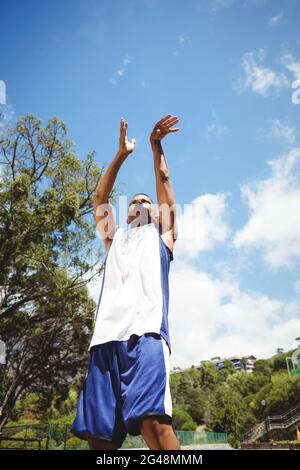 Blick aus der unteren Perspektive auf einen männlichen Teenager, der Basketball praktiziert Stockfoto