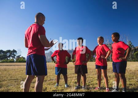 Der Trainer unterweist die Kinder im Boot-Camp Stockfoto