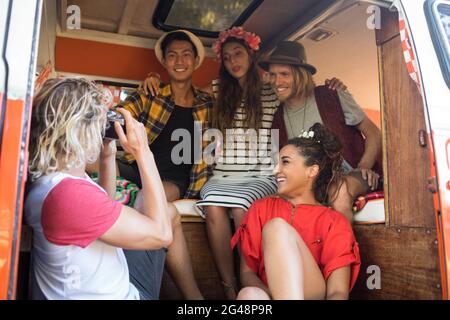 Mann fotografiert Freunde, die im Wohnmobil sitzen Stockfoto