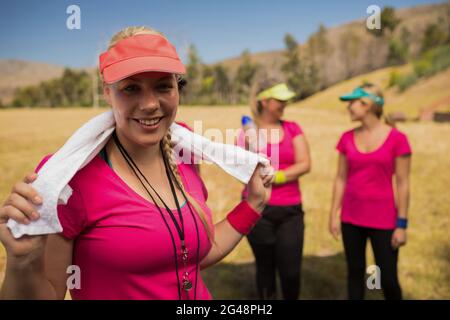 Weibliche Trainerin mit Handtuch um den Hals im Boot Camp Stockfoto