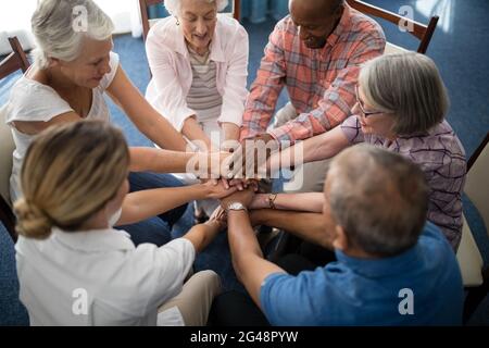 Aus der Perspektive einer Ärztin, die von Senioren mit Händen gestapelt wird Stockfoto