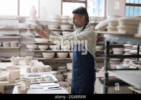 Männliche Töpfer Überprüfung Handwerk Produkt Stockfoto