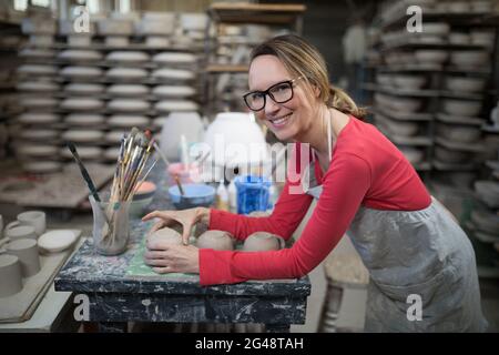 Porträt einer Frau, die Becher an der Arbeitsplatte überprüft Stockfoto