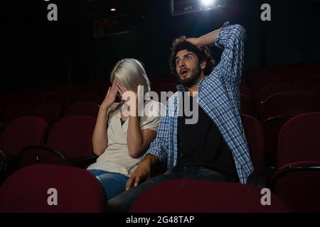 Ein Paar mit schockierten Gesichtsausdruck, der den Film ansieht Stockfoto