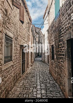 Idyllische leere schmale gepflasterter Steinstraße in der Altstadt mit Steinhäusern in Trogir, Kroatien. Stockfoto