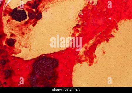 Erdnussbutter und rote Marmelade im Hintergrund, Draufsicht Stockfoto