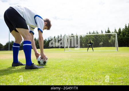 Junge männliche Fußballspieler spielen gegen den Himmel Stockfoto