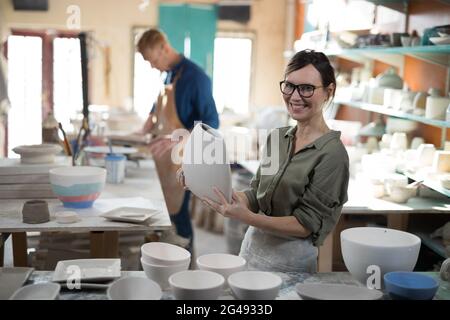 Portrait von weiblichen Töpfer Überprüfung Handwerk Produkt Stockfoto