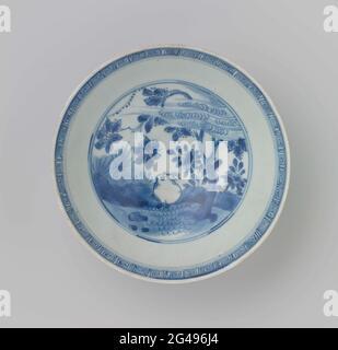 Schale mit einem Hasen in einer Landschaft. Niedrige Schale aus Porzellan, in Unterglasur blau lackiert. Auf der Vorderseite eine Landschaft im Doppelkreis mit einem Hasen in blühenden Pflanzen. Der innere Rand mit einem Band mit einem Mäandermuster. Drei Insekten an der Außenwand. Auf der Unterseite ist das Zeichen von Kaiser Chenghua mit sechs Zeichen in einem doppelten Kreis markiert. BAK Sand am Fußring. Blauweiß. Stockfoto