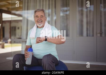 Älterer Mann, der nach der Arbeit die Zeit auf der Armbanduhr überprüft Stockfoto