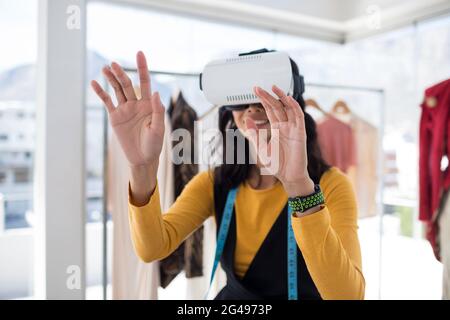 Weibliche Designerin, die ein Virtual-Reality-Headset verwendet Stockfoto
