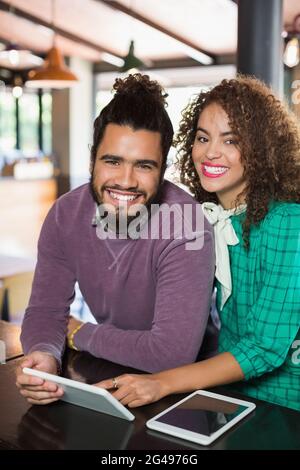 Fröhliche Freunde mit digitalen Tablets im Restaurant Stockfoto