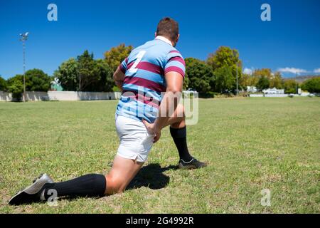 Rückansicht des Rugby-Spielers beim Training auf dem Rasen Stockfoto