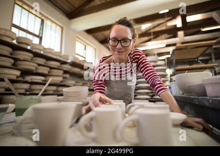 Frau überprüft Becher an der Arbeitsplatte Stockfoto