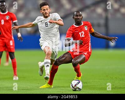 Doha, Katar. Juni 2021. Nasr Eldin (R) aus dem Sudan steht während des FIFA Arab Cup Qatar 2021-Qualifikationsrunden-Fußballspiels in Doha, Katar, am 19. Juni 2021 mit Nouradin Elgelaib aus Libyen im Spiel. Kredit: Nikku /Xinhua/Alamy Live Nachrichten Stockfoto