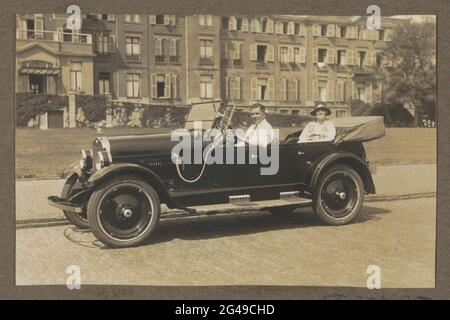 Mann und Frau sitzen im Auto, möglich in Scheveningen. Teil des Fotoalbums einer unbekannten holländischen Familie mit Aufnahmen von Suriname, Europa und Niederländisch-Ostindien. Stockfoto