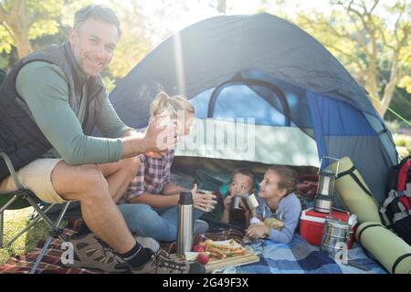 Familie mit Snacks und Kaffee außerhalb des Zeltes auf Campingplatz Stockfoto