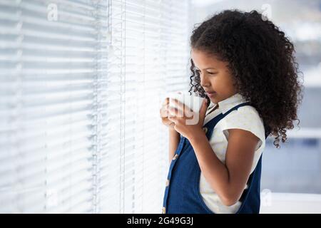 Nachdenklich Geschäftsfrau mit lockigem Haar holding Kaffeetasse Stockfoto