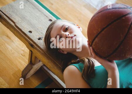 Porträt einer Basketballspielerin mit Ball auf der Bank auf dem Platz Stockfoto