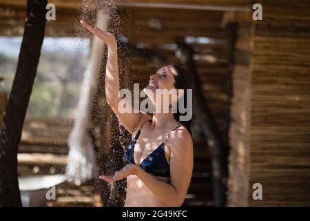 Lächelnde Frau, die in der Dusche baden geht Stockfoto