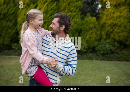 Junges Mädchen, das mit den Schultern ihres Vaters tanzt Stockfoto