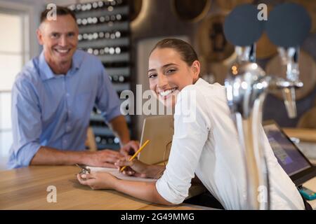 Lächelnder Manager und Barkeeper stehen an der Theke Stockfoto