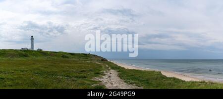 Ein Panorama des Leuchtturms und der grasbewachsenen Sanddünen über dem weißen Sandstrand bei Hirtshals im Norden Dänemarks Stockfoto