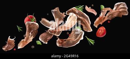 Fallende Jamon Scheiben, iberischer Schinken isoliert auf schwarzem Hintergrund Stockfoto