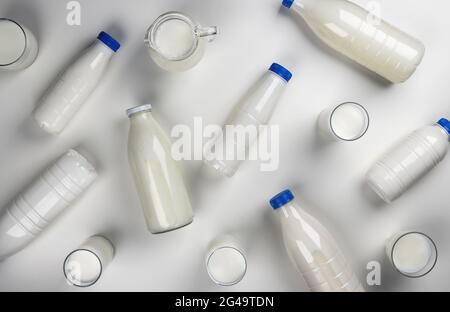 Milchprodukte, Flaschen und Gläser mit Milch auf weißem Hintergrund, Draufsicht Stockfoto