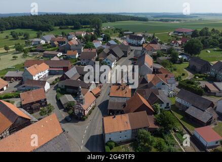 Dannenrod, Deutschland. Juni 2021. Die kleine Dorfkirche aus dem Jahr 1707 hebt sich mit ihrer Fachwerkfassade façade von den Häusern in Dannenrod ab (Luftaufnahme mit Drohne). Der weitere Bau der Autobahn A49 hat auch zu einigen tiefen Spaltungen unter den Bewohnern des kleinen Dorfes Dannenrod geführt. (To dpa: 'Permanenter Streit um A49 belastet Dörfer - 'der Zorn könnte nie verblassen') Quelle: Boris Roessler/dpa/Alamy Live News Stockfoto