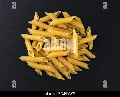 Rohe Penne Rigate Pasta isoliert auf schwarzem Hintergrund, Draufsicht Stockfoto