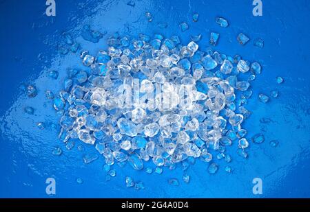 Haufen zerkleinertes Eis auf blauem Steingrund Stockfoto
