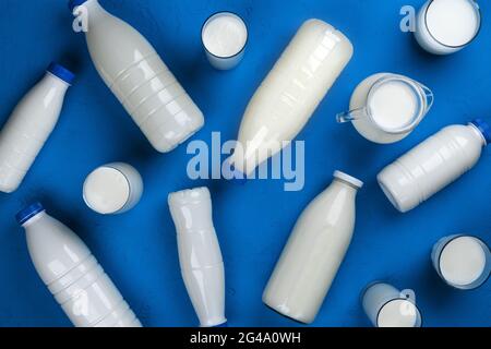 Sammlung von Flaschen und Gläsern mit Milch auf blauem Hintergrund, Draufsicht Stockfoto