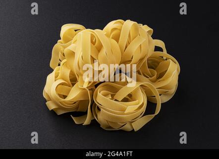 Rohe fettuccine Pasta isoliert auf schwarzem Hintergrund Stockfoto